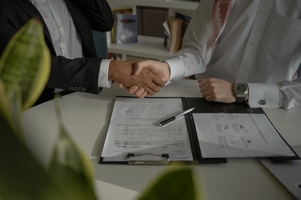 How Much Does it Cost to Send Someone to Collections: Agency Fees Explained 4 Two business professionals shaking hands across a desk