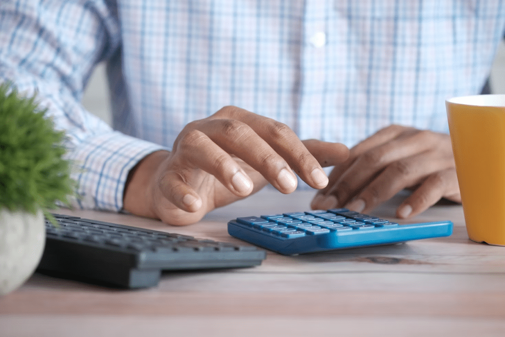 Do Collection Agencies Own the Debt? 3 A person using a calculator on a desk
