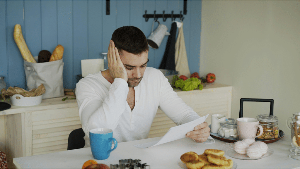 What is a Third-Party Debt Collector? 3 Man in a white shirt looking stressed while reading a document