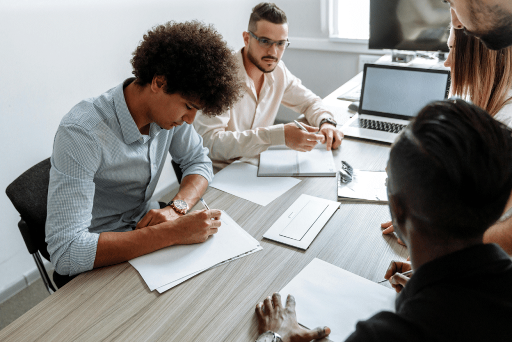Eviction Collection Agency: Reviews & Best Companies 4 People signing documents at a desk in an office setting
