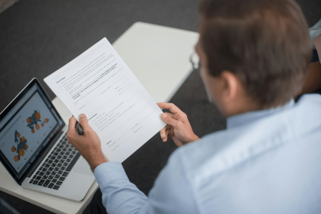 How to Hire a Collection Agency: Tips for Businesses 3 Person reviewing documents with a laptop