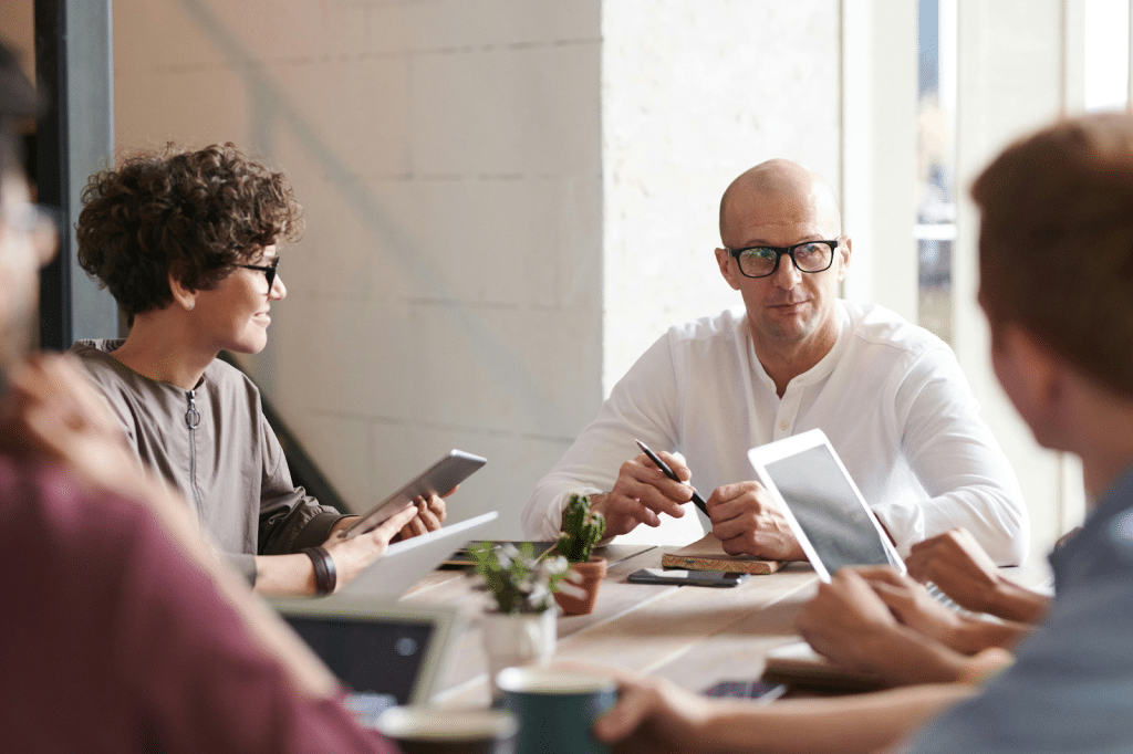 Commercial Collection Agency in Odessa, TX: Top Companies, Price & Reviews 4 Business team meeting around a table in a bright, modern office.