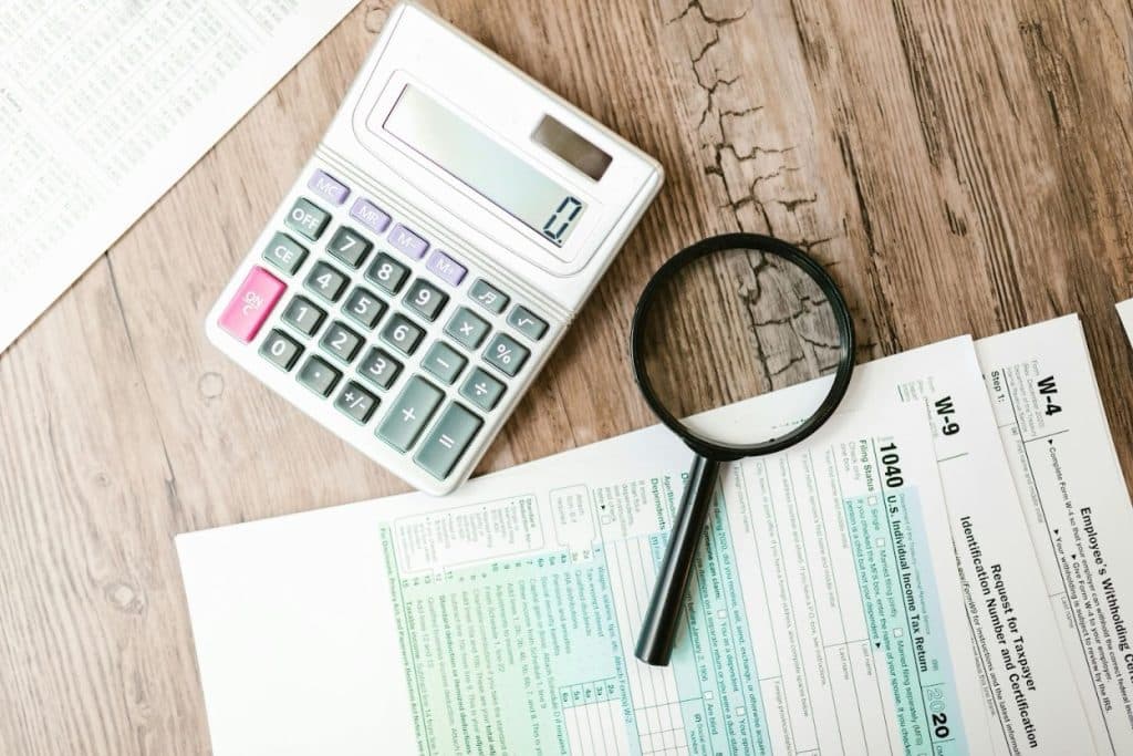Debt Collection for Small Businesses: Minimum Amount & Process Explained 3 Calculator and financial documents on a desk