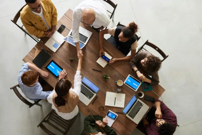 Collection Agency in Round Rock, TX: Top Companies, Price & Reviews 3 Overhead view of a business meeting with people around a conference table, two shaking hands.
