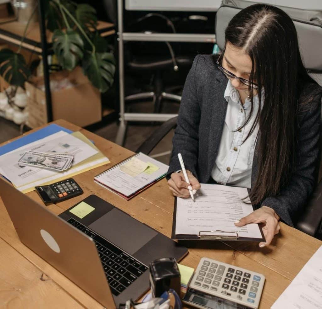 Debt Settlement vs Debt Collection: Cost & Differences Explained 5 Financial analyst going through cost spreadsheets and recovery calculations.
