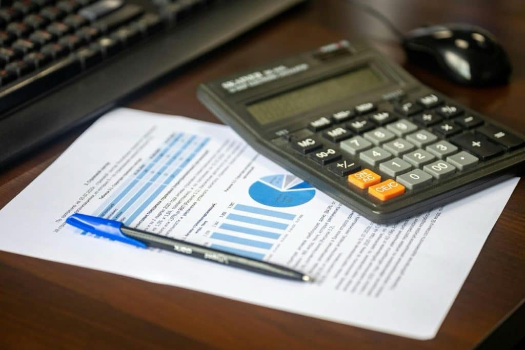 Debt Collection Agency in Conroe, TX: Cost, Reviews & Best Companies 3 Financial documents and a calculator on a desk representing collection cost calculations