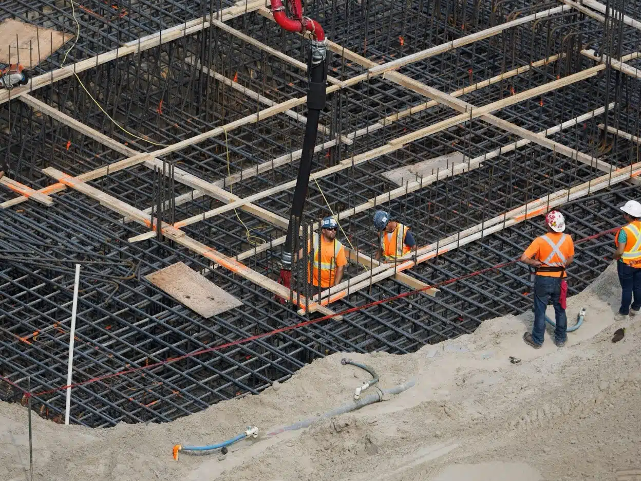 Construction Collection Agency 1 Construction workers on an active construction site with structural framing in progress