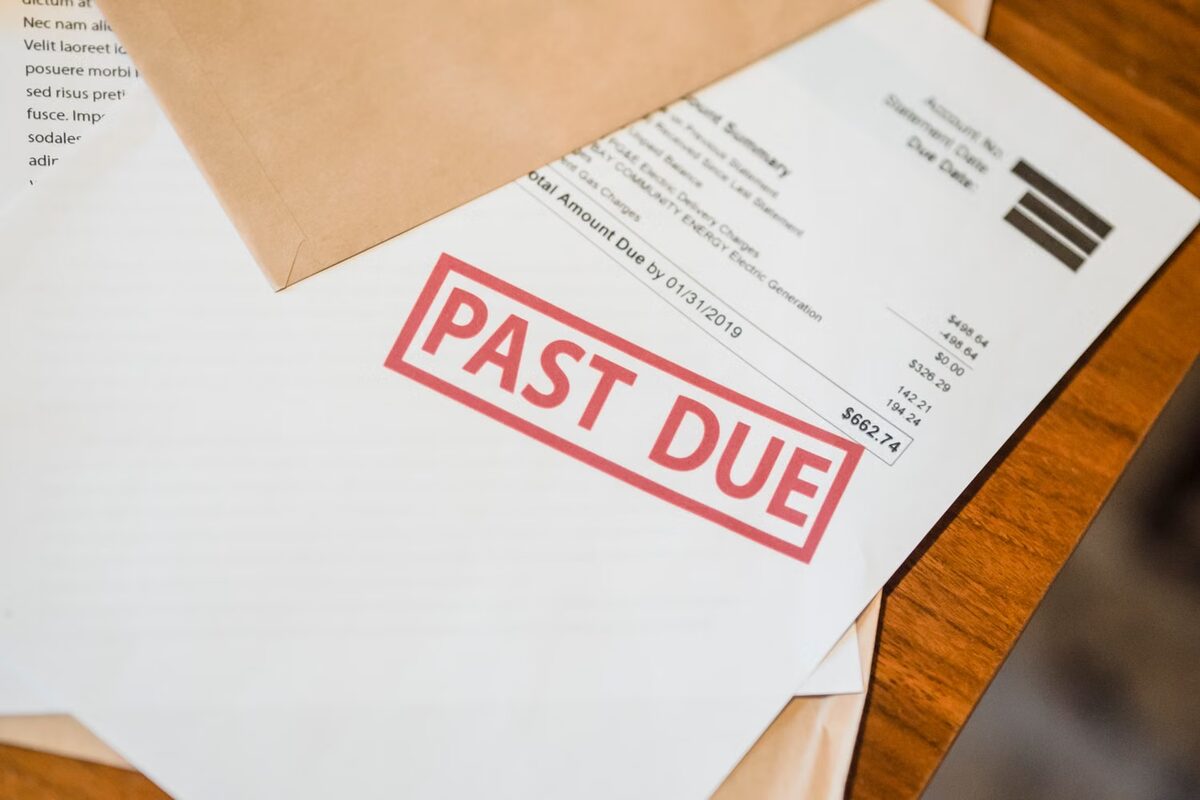 Accounts Receivable vs Debt Collection: Key Differences 3 Utility bill stamped PAST DUE showing a $662.74 overdue balance, placed on a wooden desk