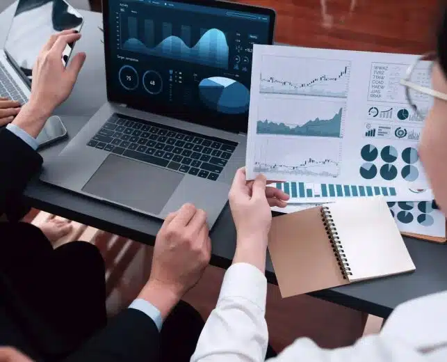 Debt Collection KPIs: Metrics Examples & Tracking 4 Two debt collectors analyzing their FCR rate using graphs and charts