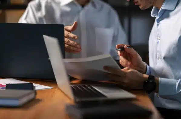 3 Best Collection Agencies for HOA Management Companies 2 Agents from a collection agency for HOA management companies reviewing account documentation